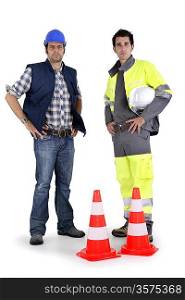 Two men standing with traffic cones in a studio