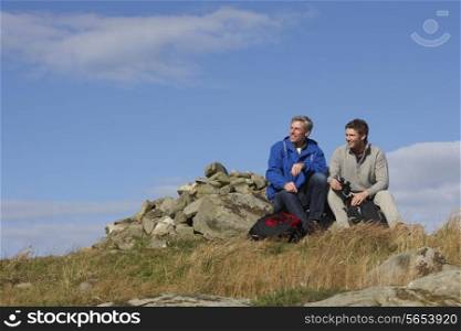 Two Men Stopping For Rest On Countryside Walk