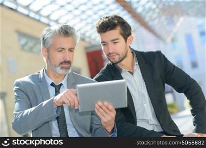 two men using digital table while having a break
