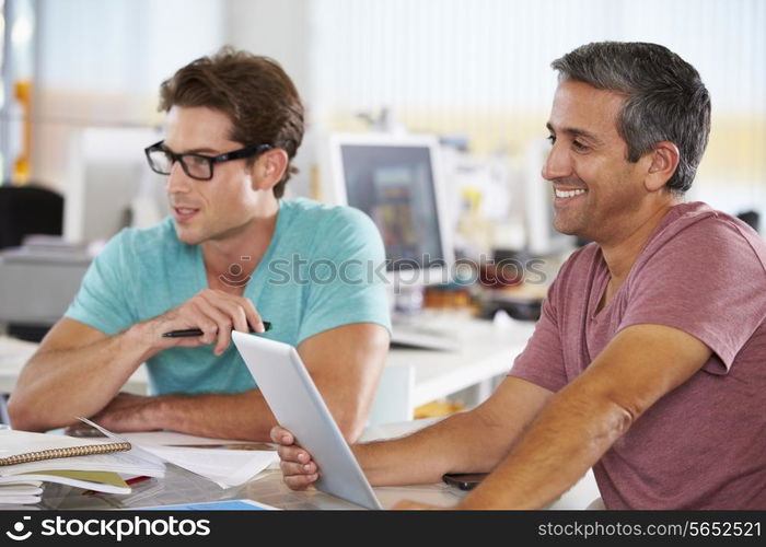 Two Men Using Tablet Computer In Creative Office