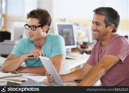 Two Men Using Tablet Computer In Creative Office