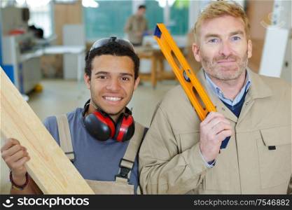 two men working together to build wooden frame