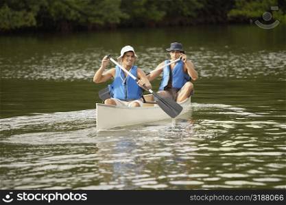 Two mid adult men canoeing