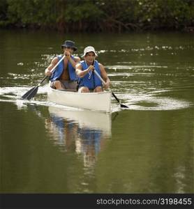 Two mid adult men canoeing