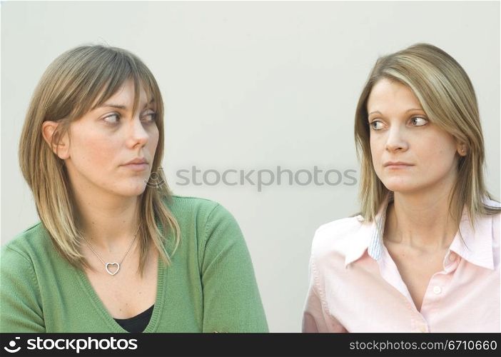 Two mid adult women staring each other
