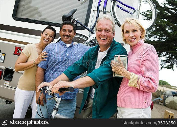 Two middle-aged couples standing beside caravan