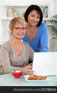 Two middle-aged women with laptop