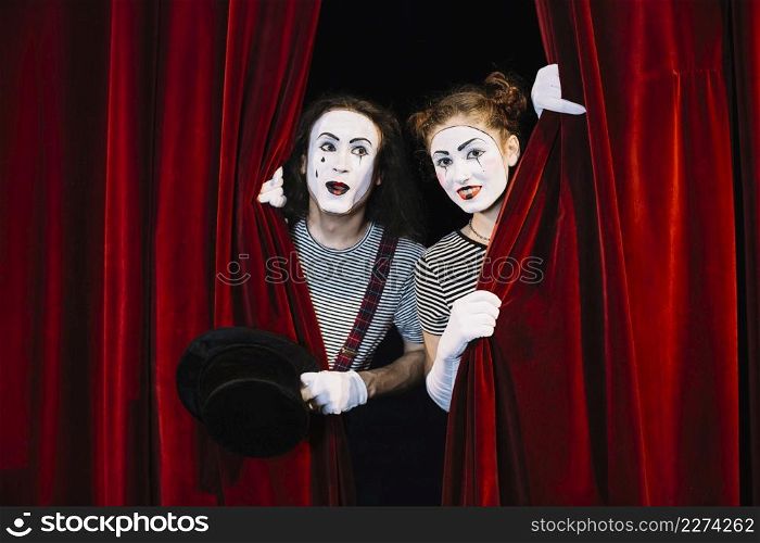 two mime artist peeking through red curtain. Resolution and high quality beautiful photo. two mime artist peeking through red curtain. High quality beautiful photo concept