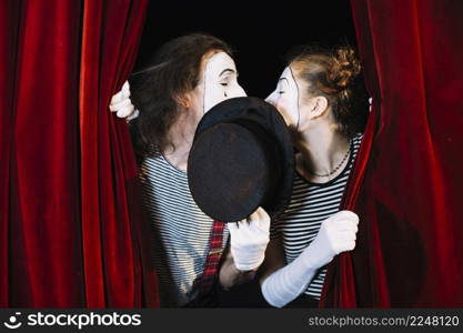 two mime artist standing curtain kissing