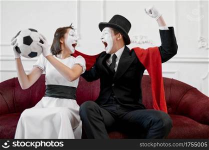 Two mime artists, football fans parody. Pantomime theater, comedian, positive emotion, humour performance, funny face mimic and grimace. Two mime artists, football fans parody