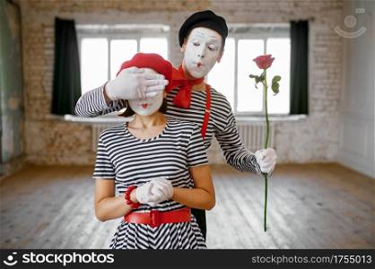 Two mime artists, surprise with rose scene, parody comedy. Pantomime theater, comedian, positive emotion, humour performance, funny face mimic and grimace. Mime artists, surprise with rose scene