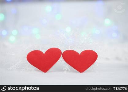 Two mini heart pillow on the white fur, bokeh background, with copy space for season greeting, Happy New Year, AF point selection, blurred.
