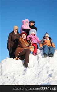 two mothers with grandfather and children on snow hill