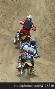 Two motocross riders riding motorcycles