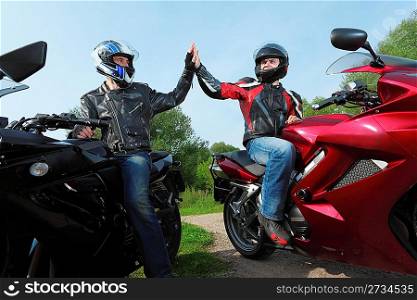 two motorcyclists greetings on country road
