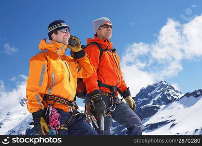 Two mountain climbers standing on peak