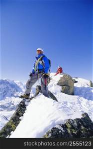 Two mountain climbers standing on snowy mountain