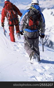 Two mountain climbers walking in snow (selective focus)