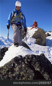 Two mountain climbers walking on snowy rocks (selective focus)