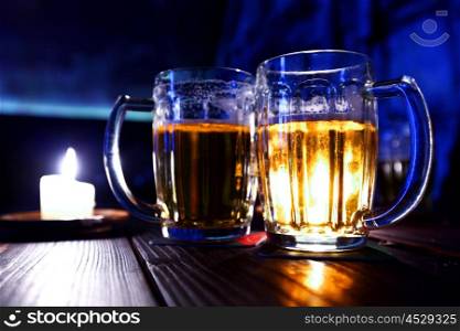Two mugs of beer on table in bar. Two mugs of beer