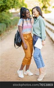 Two multiethnic girls posing together with colorful casual clothing outdoors.. Two multiethnic girls posing together with colorful casual clothing