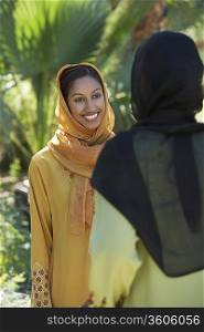 Two muslim woman in traditional clothing talking