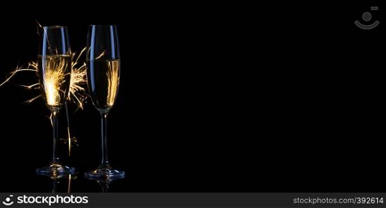 Two narrow glasses of champagne against the background of Bengal lights. Black background. The concept of the celebration of the wedding and the new year. Copy space.. Two narrow glasses of champagne against the background of Bengal