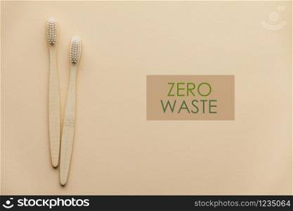 Two natural wooden toothbrushes on color background, flat lay, top view. Concept of zero waste and dental care. Copyspace