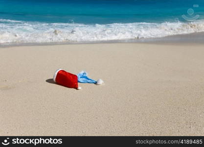 Two New Year&acute;s caps of Santa Claus on beach