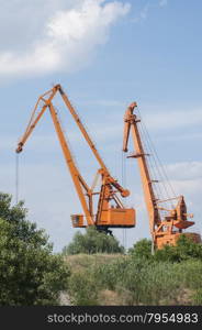 Two obsolete port tower bulk cranes in sunny day