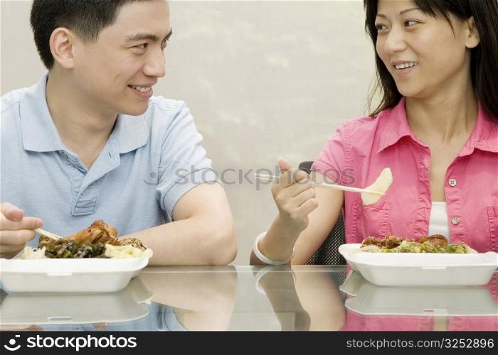 Two office workers having lunch and smiling