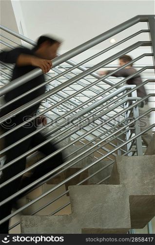 Two office workers walking up stairs