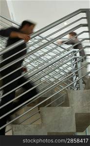 Two office workers walking up stairs