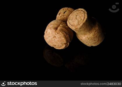 Two old wine corks on a black background with reflection. Wine corks on black background