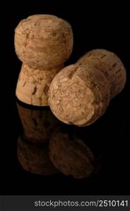 Two old wine corks on a black background with reflection. Wine corks on black background