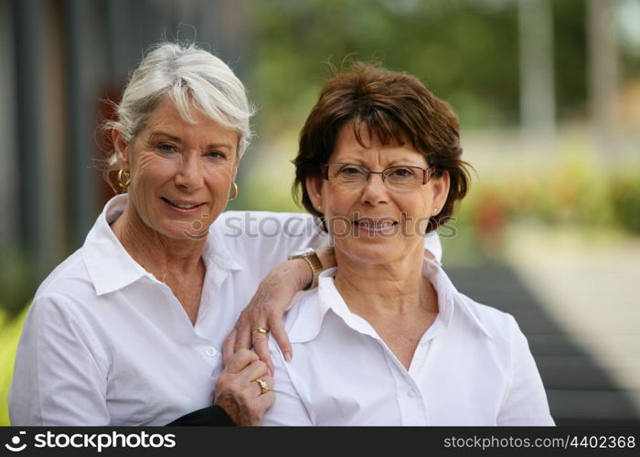 Two older women standing outside