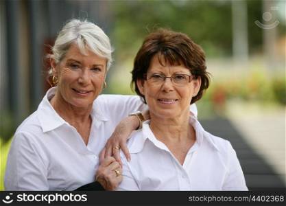Two older women standing outside