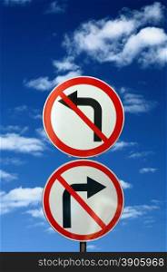 two opposite road signs against blue sky and clouds