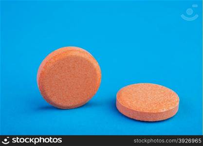 two orange tablets on a blue background&#xA;