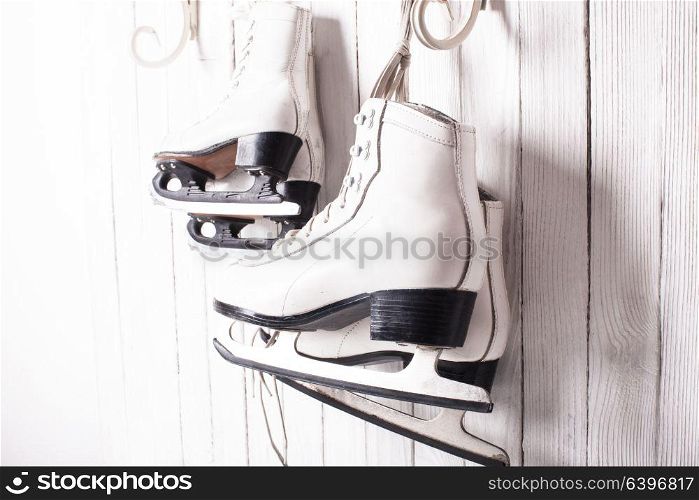 Two pairs of skates hanging on the hook. Family skating concept. Skates close up