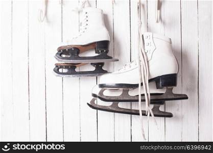 Two pairs of skates hanging on the hook. Family skating concept. Skates close up