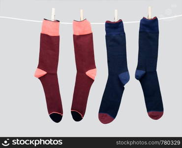 Two pairs of socks hanging from a clothes line.