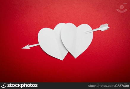 Two paper hearts pierced with an arrow symbol for Valentines day  with copy space for text or design