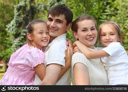 two parents hold children on hands