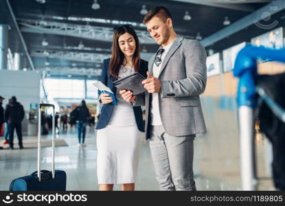 Two passengers of business class in airport, working trip. Businessman and businesswoman in air terminal, negotiation travel