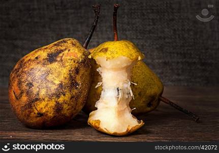 Two pears and stub standing on wooden table background sacking