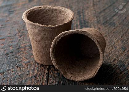 Two Peat Pots on is wooden background