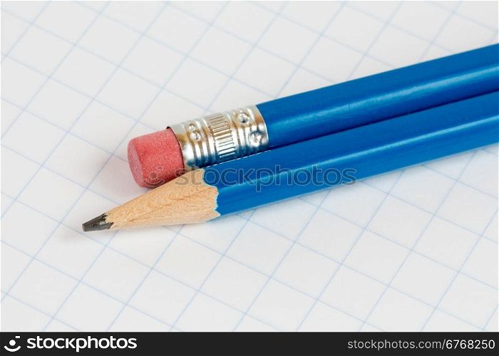 Two pencils on the square exercise book