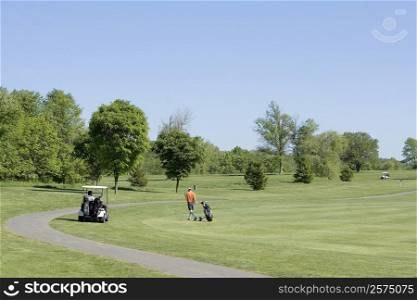 Two people and a golf cart on a golf course