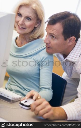 Two people at computer looking at monitor (high key)